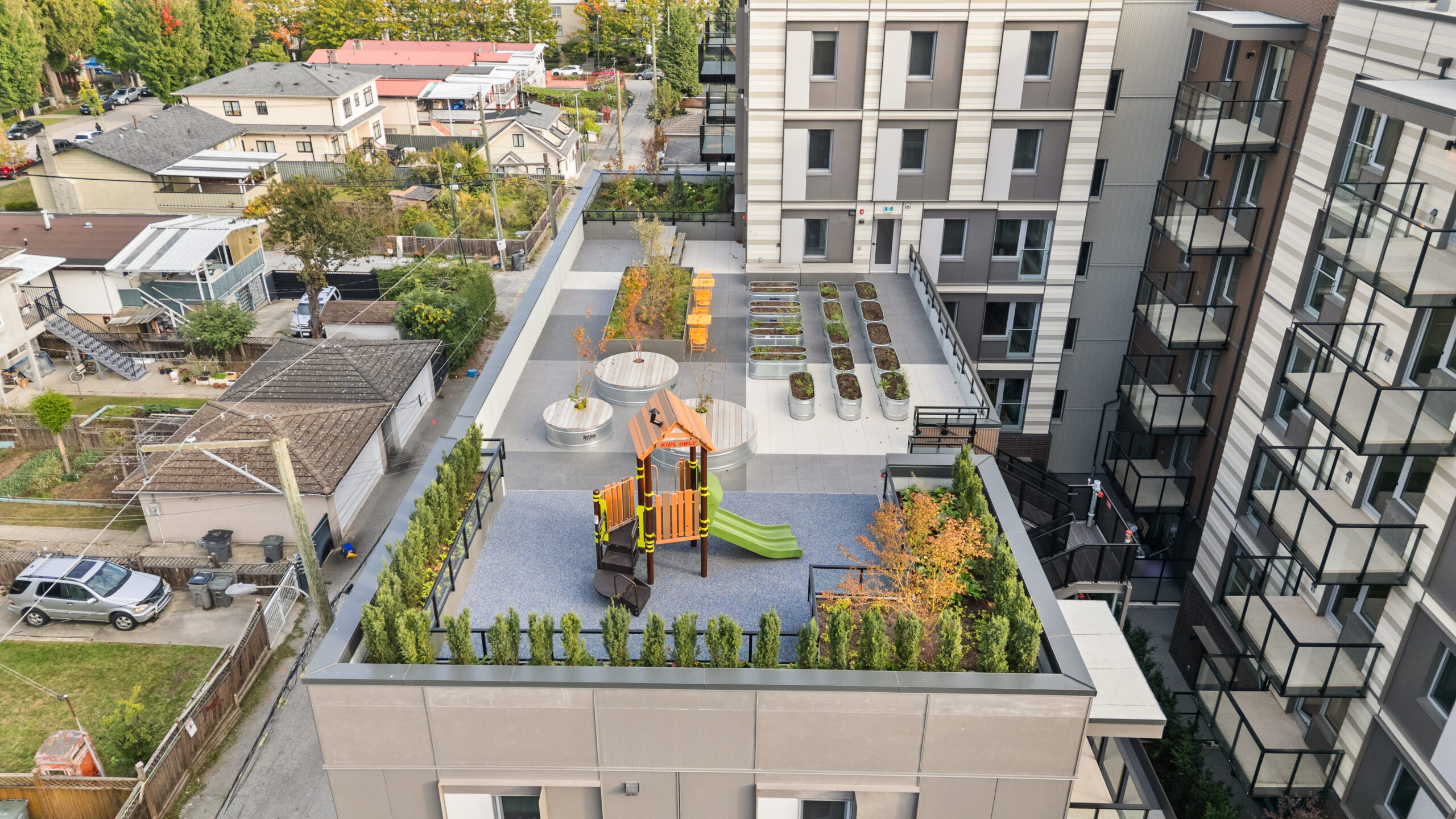 Rooftop play area and garden at McHardy apartment building in Vancouver, with playground equipment and seating.
