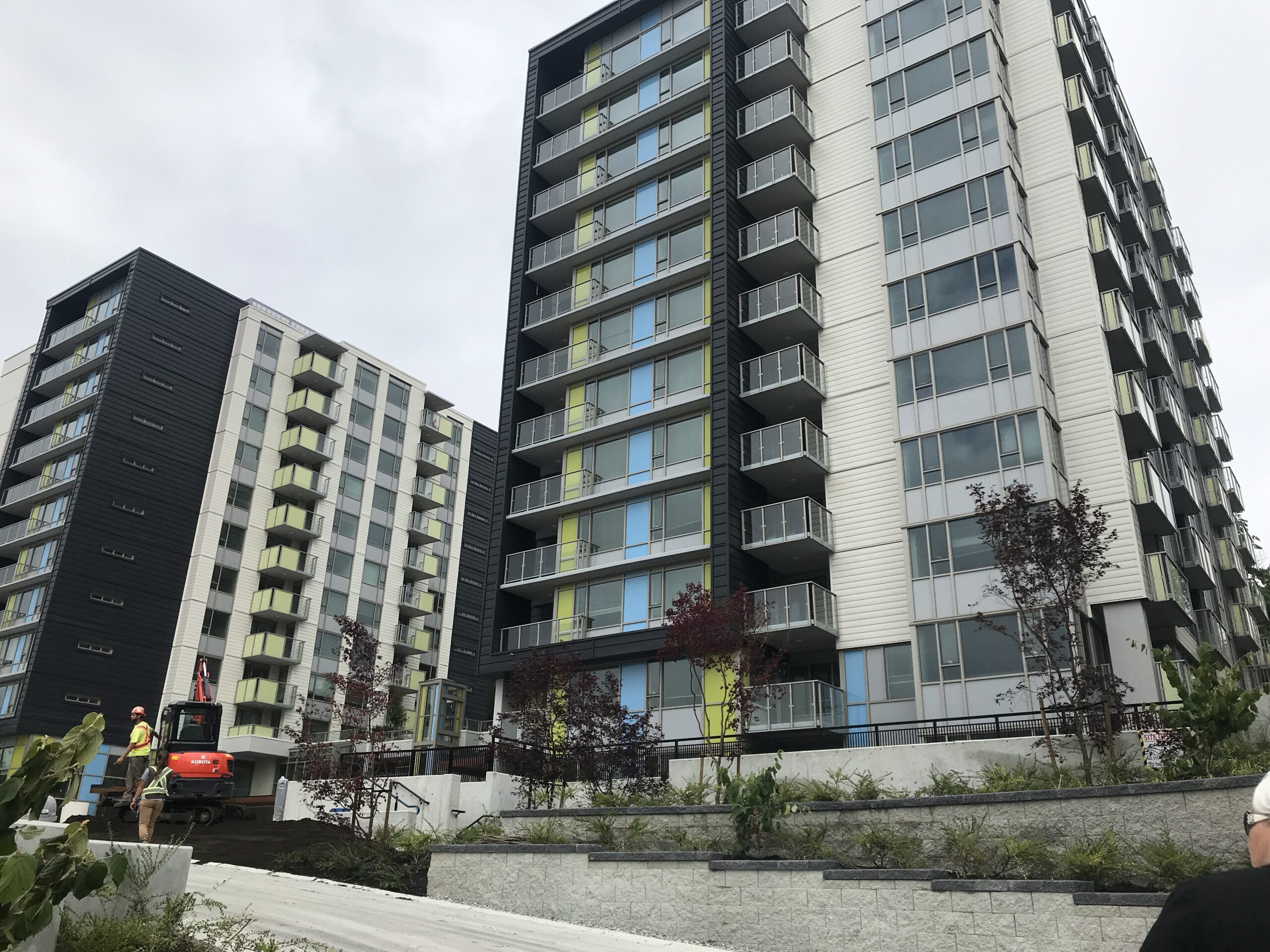 wo modern high-rise residential towers with balconies, photographed from ground level.
