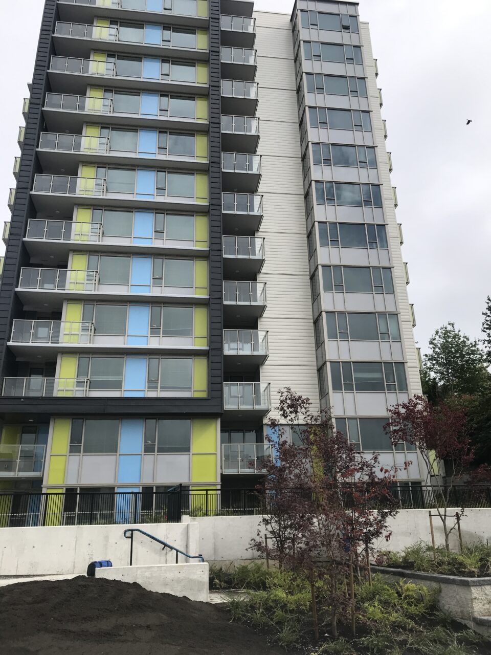 Exterior view of two high-rise residential towers with balconies and landscaped grounds.