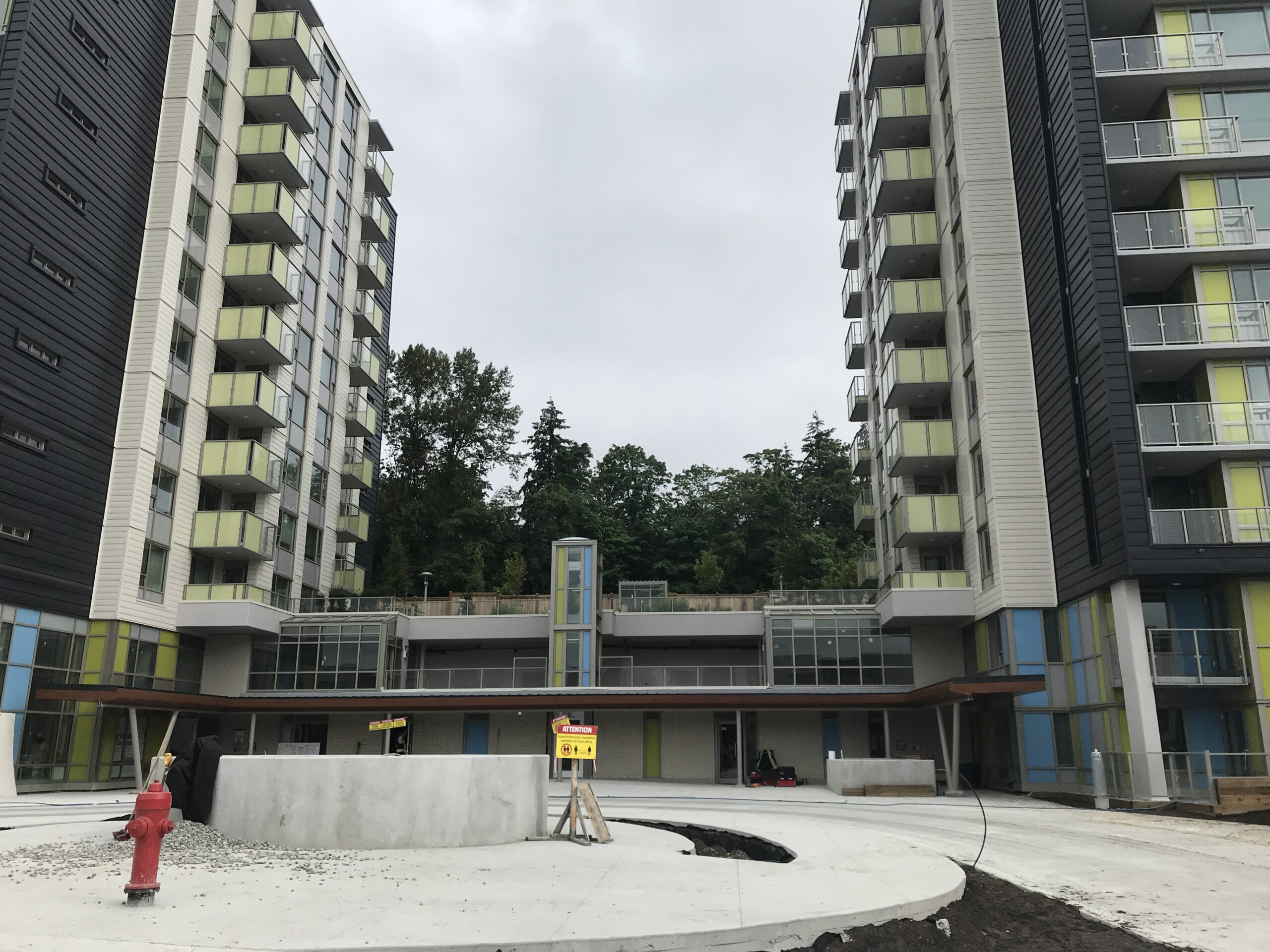 Courtyard view between two high-rise residential buildings with balconies.