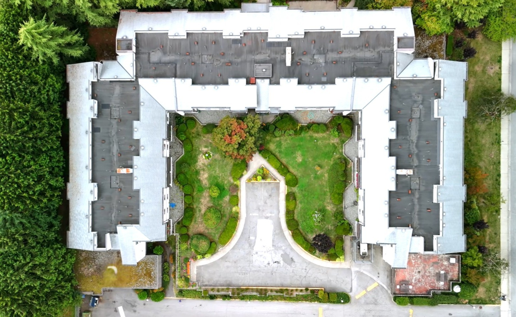 Aerial view of Packard affordable housing co-op with U-shaped layout, central landscaped courtyard, and surrounding greenery.
