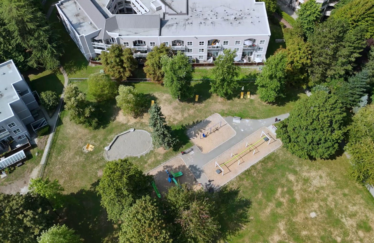 Aerial view of Post 83 Housing Co-op in Burnaby with playground, swings, and landscaped green space.