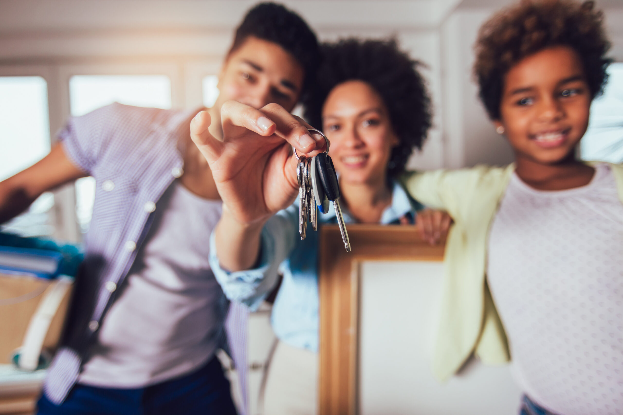 Family holds up the keys to their new home.